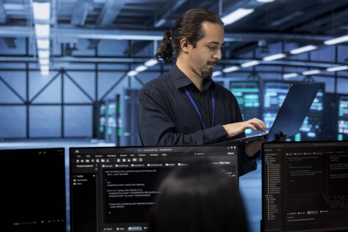 un homme tenant un ordinateur portable